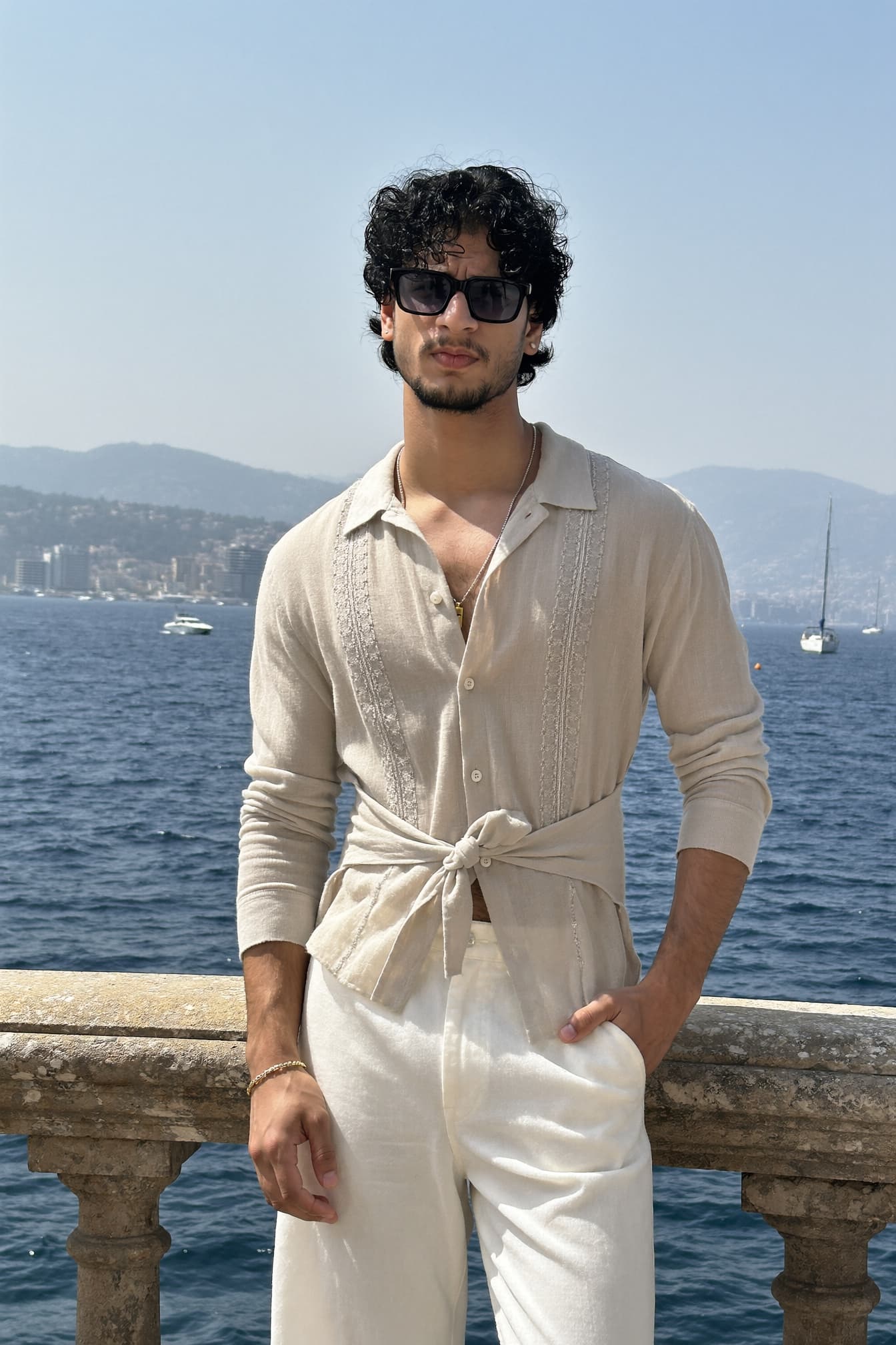 Aman Singh by the sea in a cream linen shirt